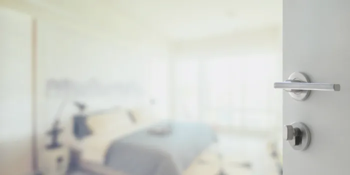 opened white door to abstract background of modern bedroom interior