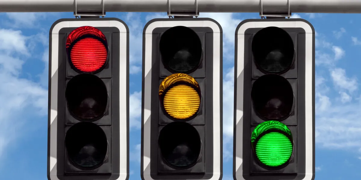 three traffic lights against blue sky background