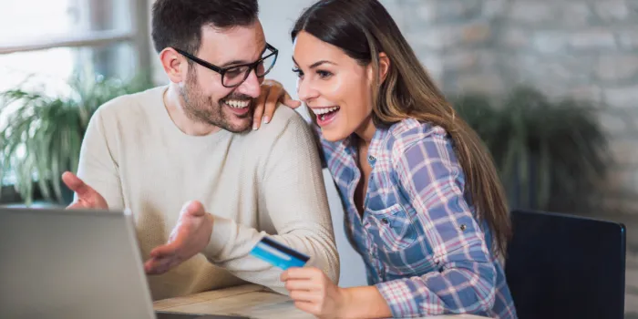 young couple with laptop computer and credit card buying online