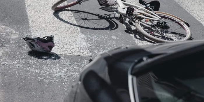 helmet next to bike on crosswalk after collision with car