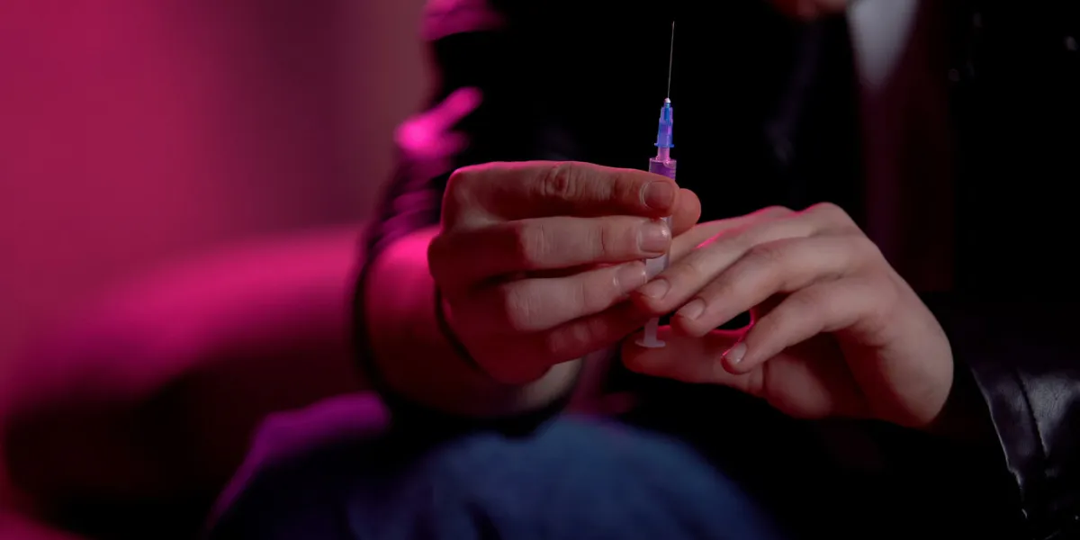 junky holding syringe, preparing to make injection, drug abuse problem concept