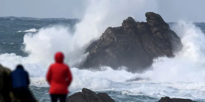 people watch high waves crashing at porspoder, western france on december 27, 2020, as storm bella strikes the coast of britanny (photo by fred tanneau   afp)