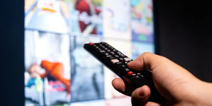 man's hand holding a remote control, multimedia, online tv, broadcasting entertainment to viewers at home the idea behind the broadcast