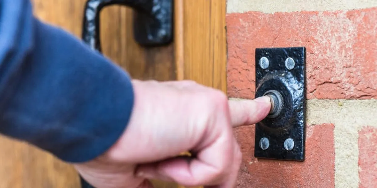 closeup on a hand pressing a door bell button