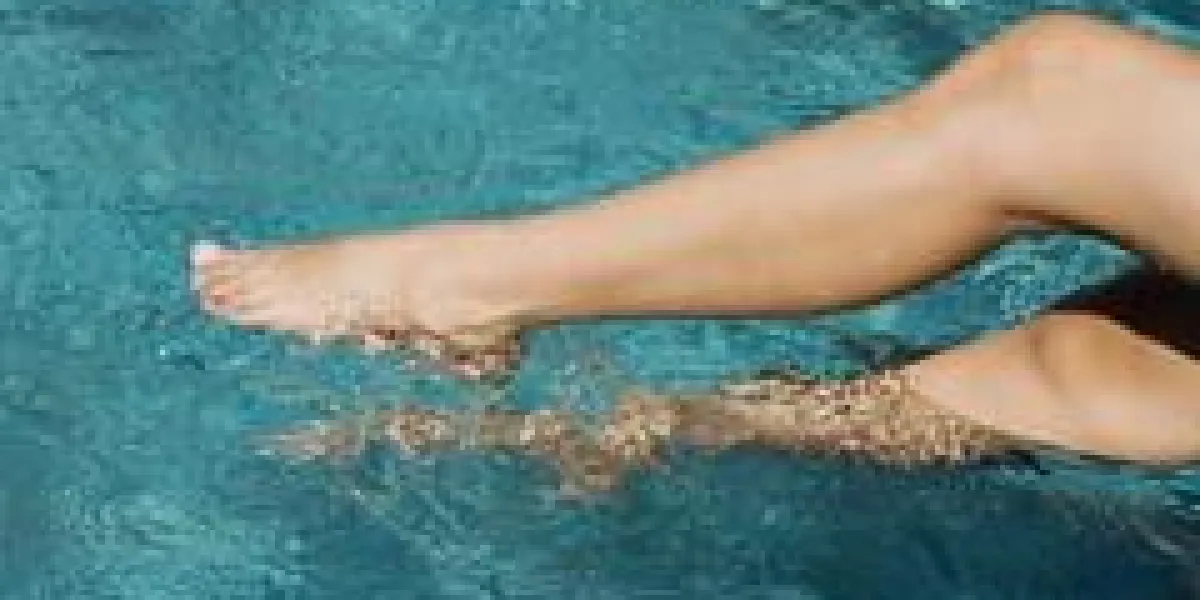 femme plongeant les jambes dans la piscine
