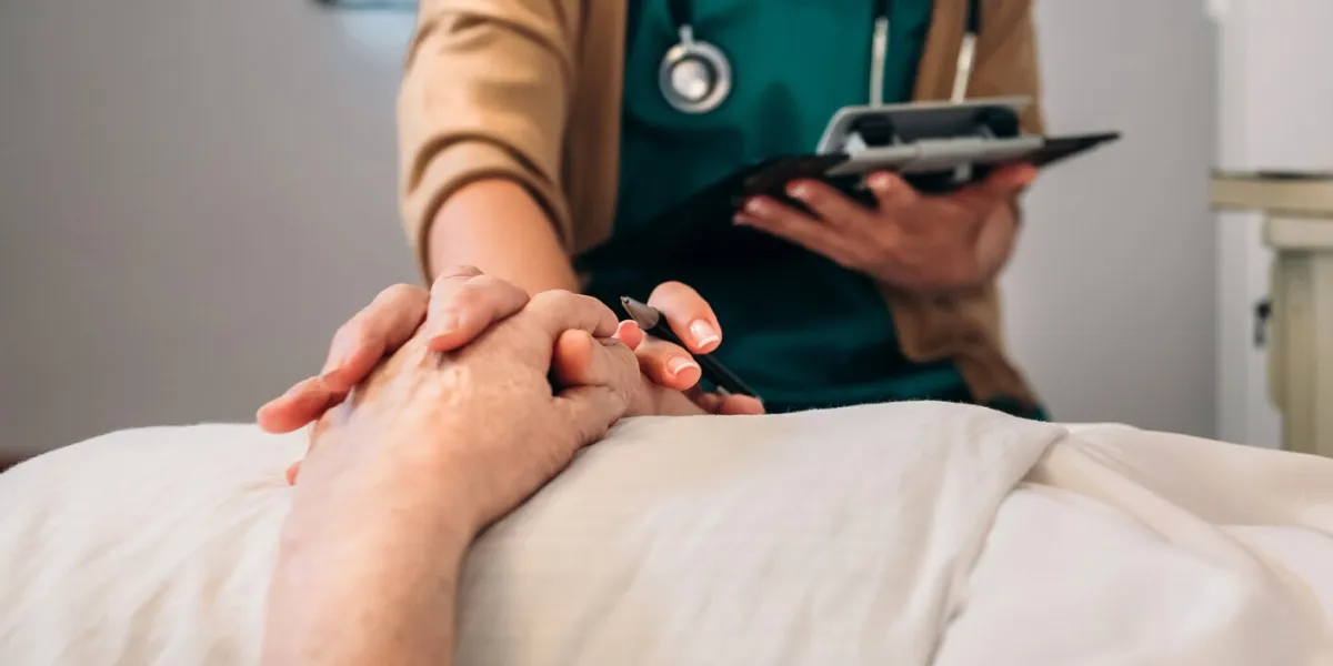 unrecognizable young female doctor comforting unrecognizable older female patient
