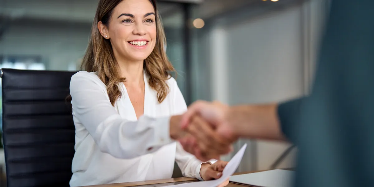 happy mid aged business woman manager handshaking at office meeting smiling female hr hiring recruit at job interview, bank or insurance agent, lawyer making contract deal with client at work