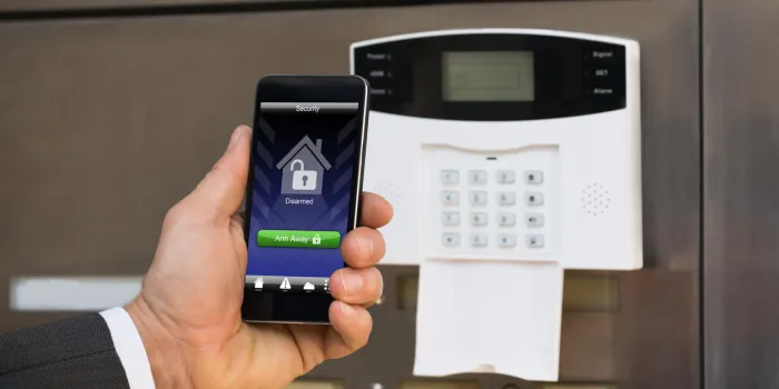 close-up of businessperson hand holding smartphone for arming the system