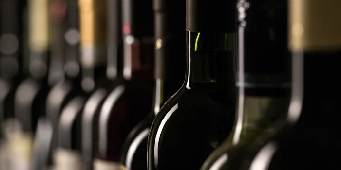 row of vintage wine bottles in a wine cellar, vinery background