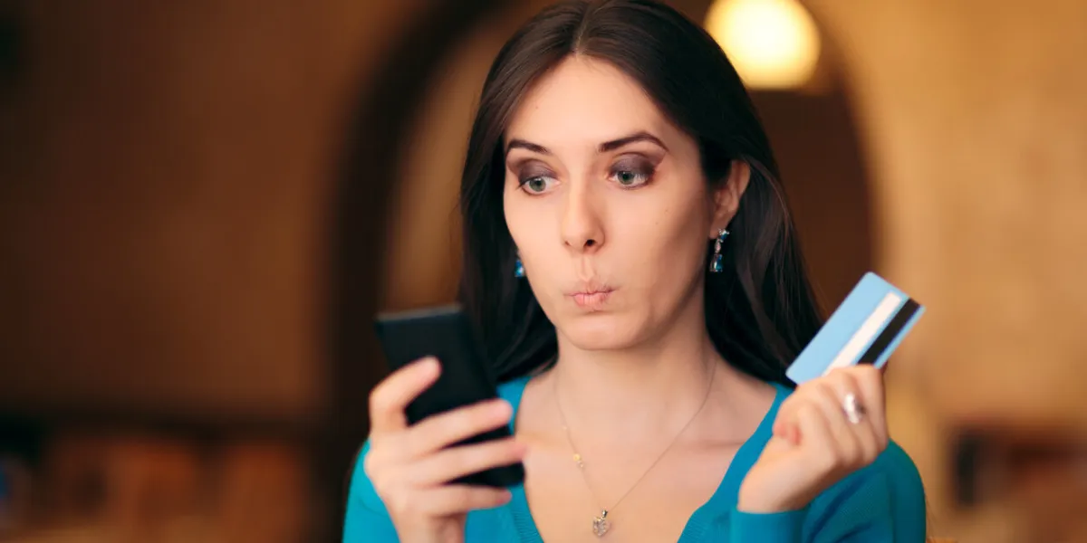 woman holding credit card and smartphone shopping online