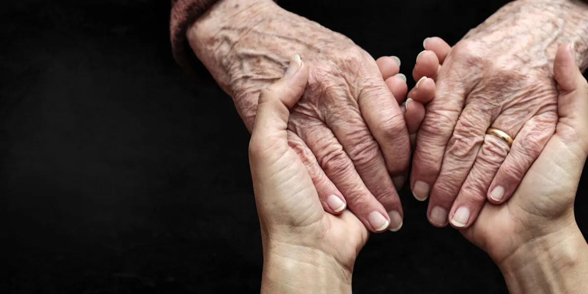 the hands of a young woman welcome those of an elderly woman