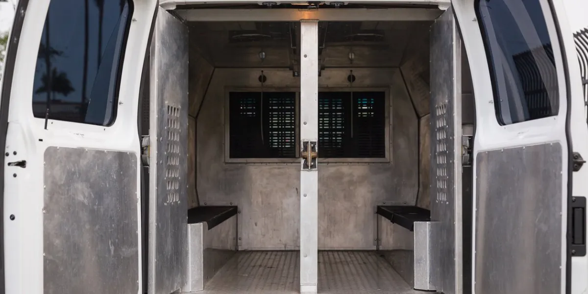 rear view of a police van for the transportation of prisoners parked near the police station inside a police car open doors of a police van