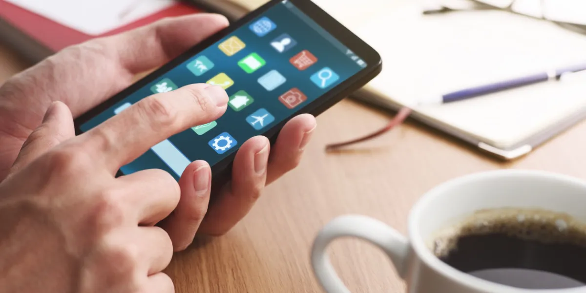 closeup of male hands touching smartphone screen for using app at table