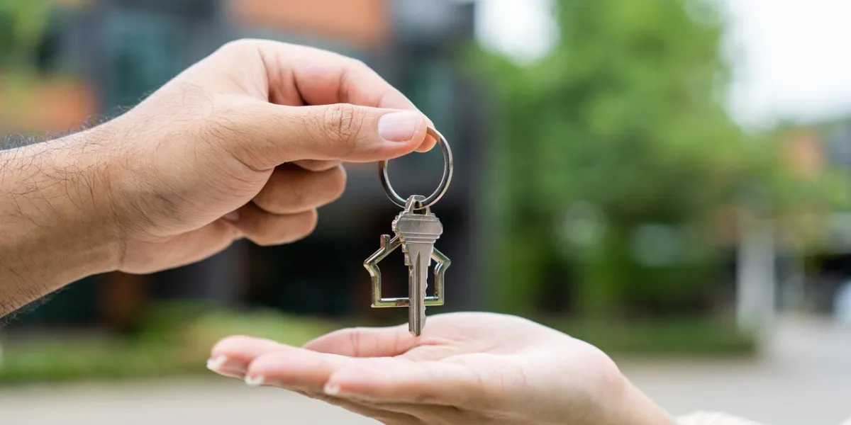 woman buying or rent new home she holding key front of new house surprise happy young asian woman giving house key and smile to rent or purchase apartment home moving relocation concept