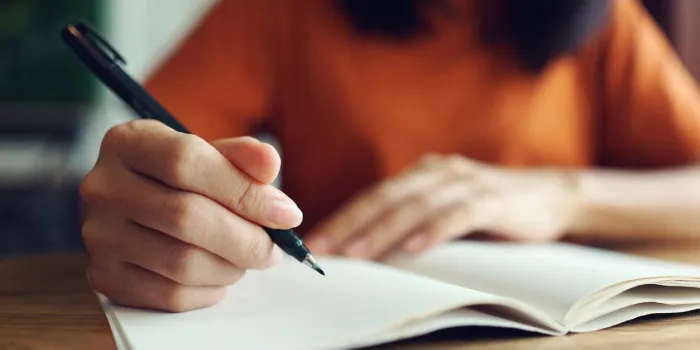 close up woman hand writing on notebook