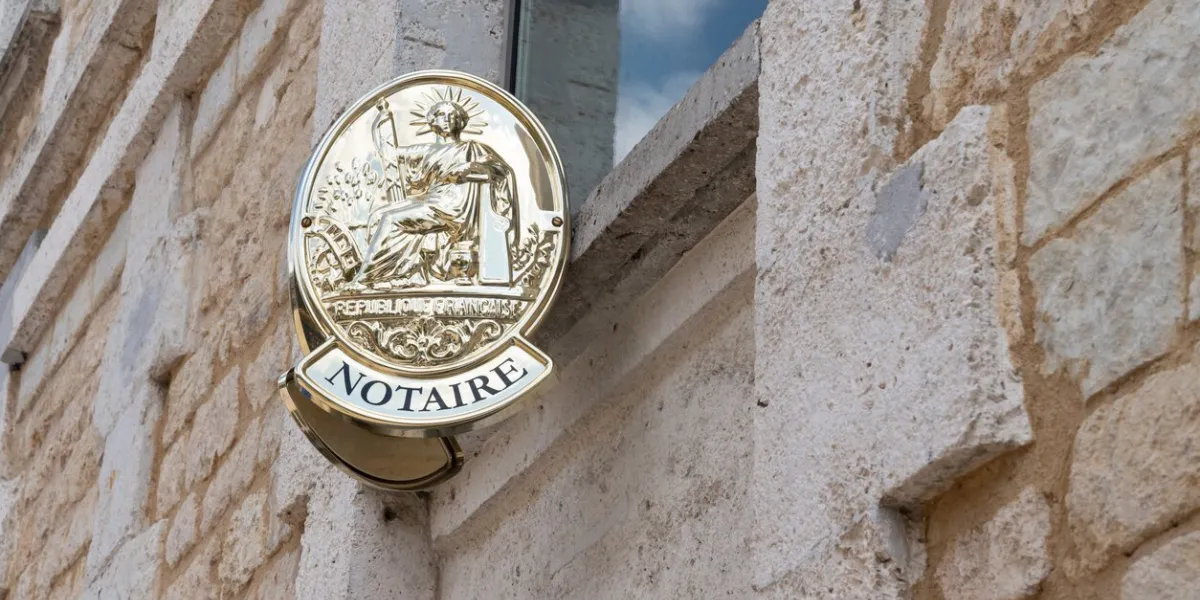 french notaire sign on wall above entrance to the notary office