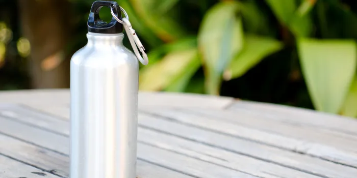 reusable water bottle on a wooden table outdoors