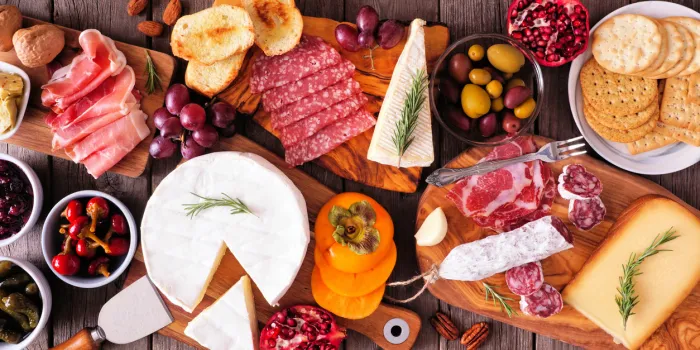 charcuterie boards of assorted meats, cheeses and appetizers top view table scene on a rustic wood background