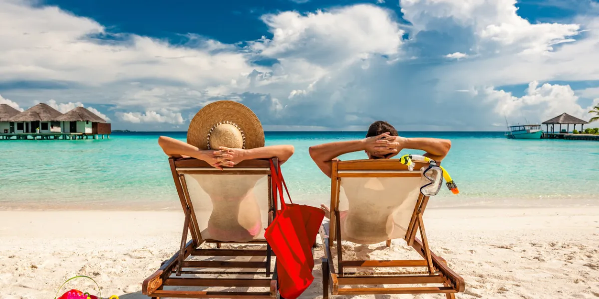 couple in loungers on a tropical beach at maldives