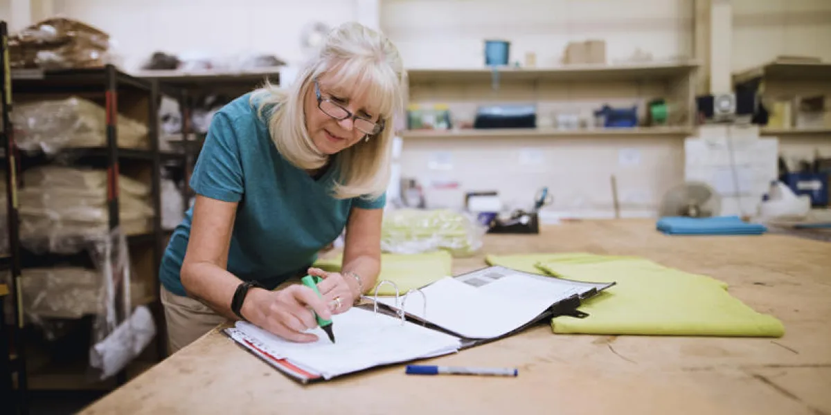senior businesswoman is doing paperwork in her stock factory