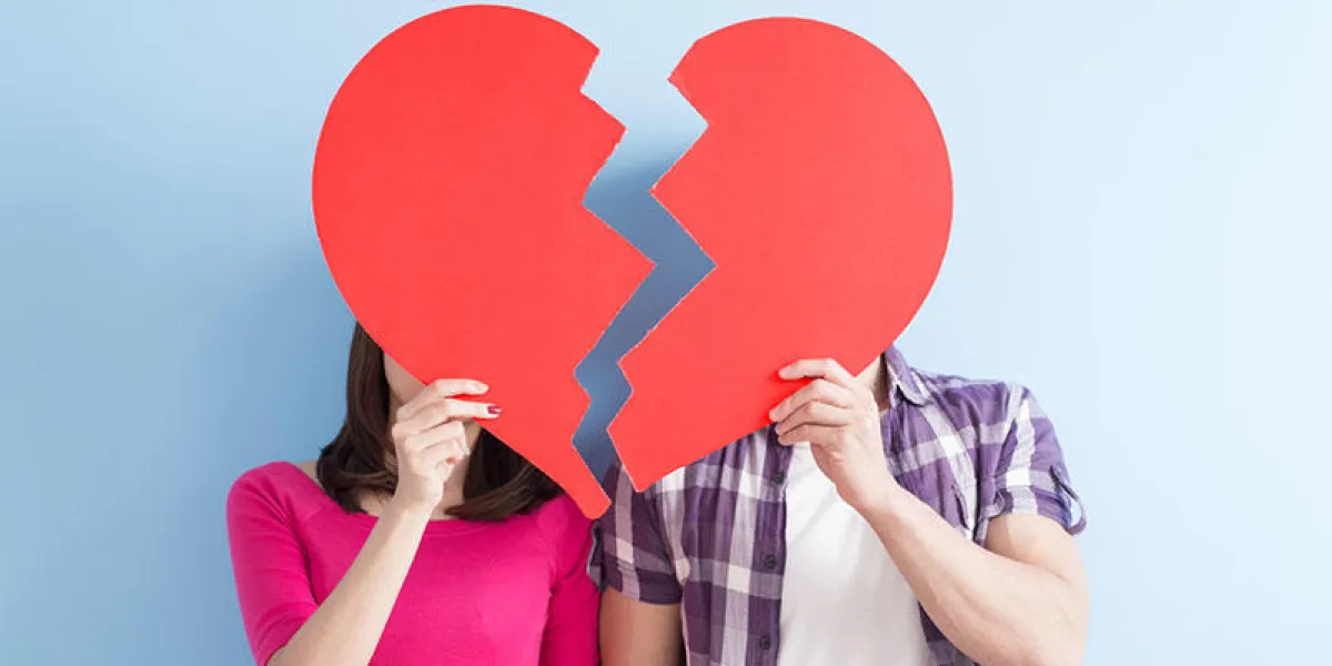 young couple take broken heart isolated on blue background