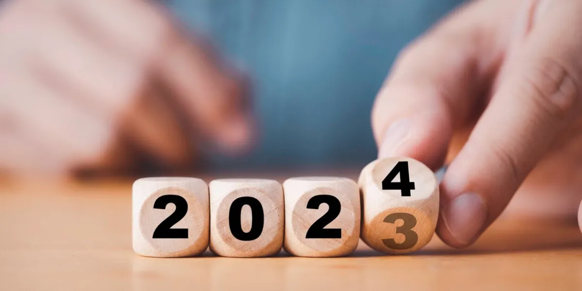 hand flipping of 2023 to 2024 on wooden block cube for preparation new year change and start new business target strategy concept