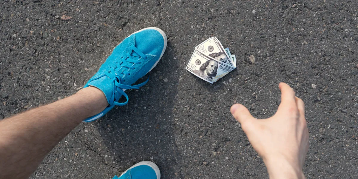 person find paper money lost and dropped on the asphalt ground outdoor