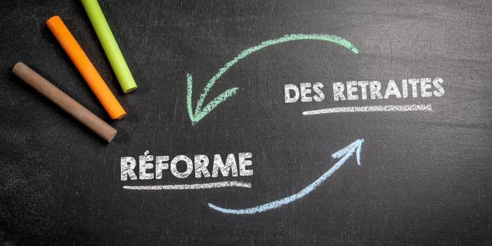 pension reform in french text on a dark chalk board