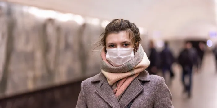 young attractive european caucasian woman in a protective mask protecting against influenza viruses and coronavirus covid-19 i in the subway