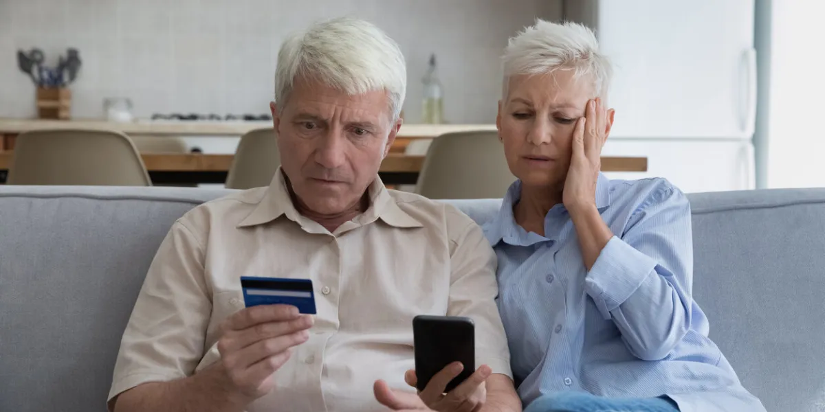shocked aged couple become victims of online fraud using credit card phone to pay for goods order service online on suspicious website frustrated older spouses overspending money at internet shopping