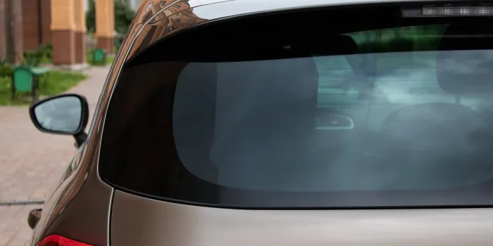 back window of a car parked on the street in summer sunny day, rear view