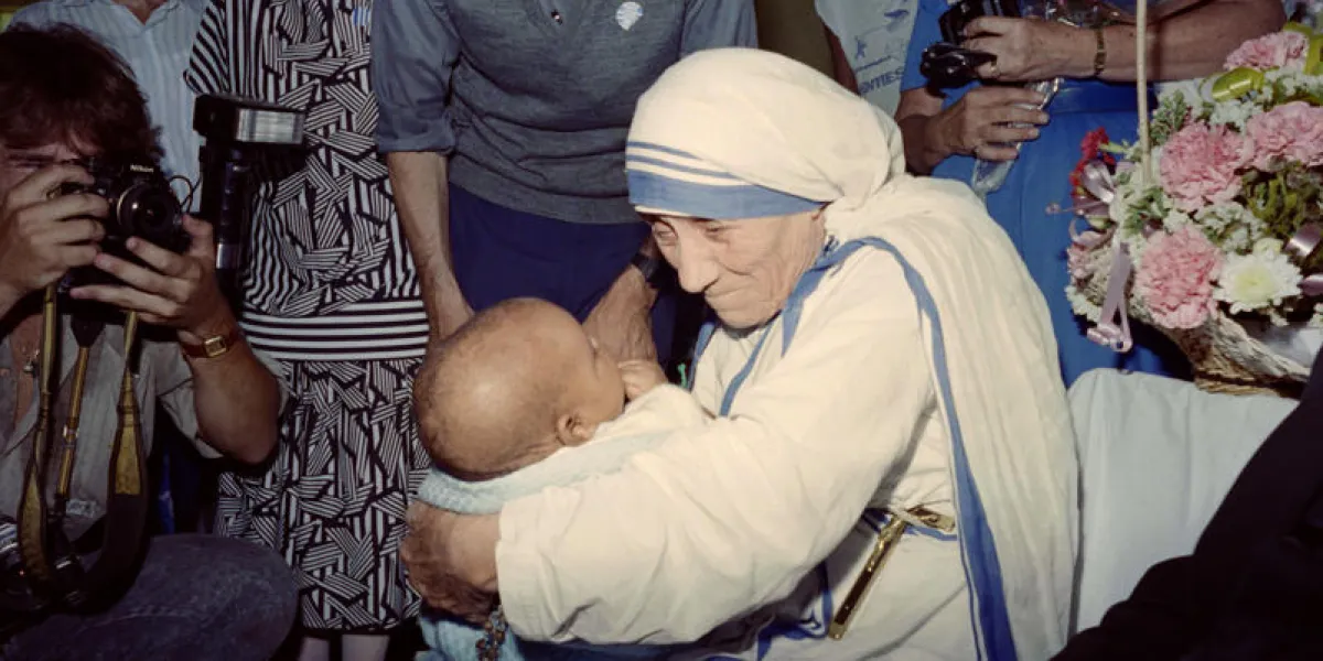mother teresa of calcutta (c) holds a baby on november 15, 1988 in johannesburg, during her 8th an final day of her visit in south africa   afp photo   walter dhladhla