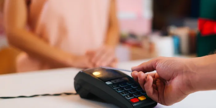 close-up view of unrecognizable male customer paying with nfc technology by credit card contactless on pos terminal, selective focus, blurred background contactless payment using debit card