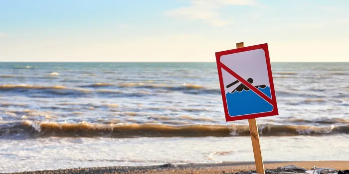 warning no swimming sign with strong sea wave by the beach background