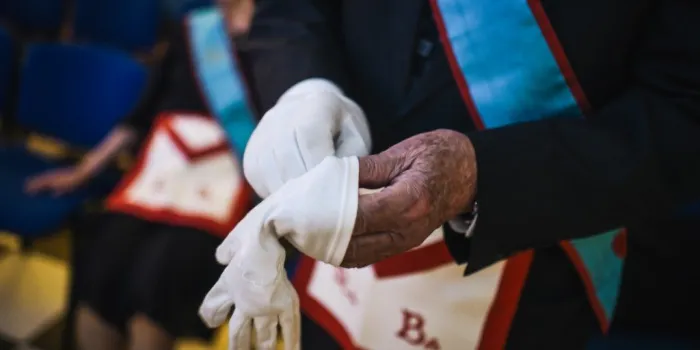 a french freemason puts his gloves on his hands during a meeting inside a masonic temple in suresnes, west of paris, on may 27, 2019 (photo by lucas barioulet   afp)