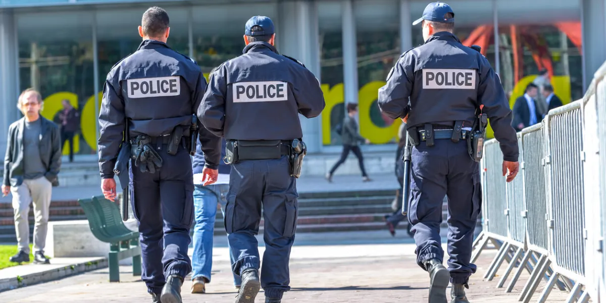 la defense, france - april 10, 2014  back view of tree police officers walking in the center of la defense, great business block near paris