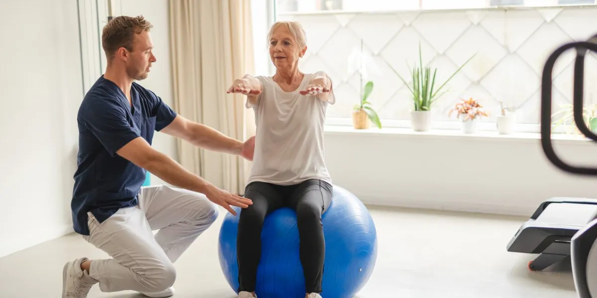 a young physiotherapist guiding an elderly woman through rehabilitation exercises, empowering her on the path to wellness