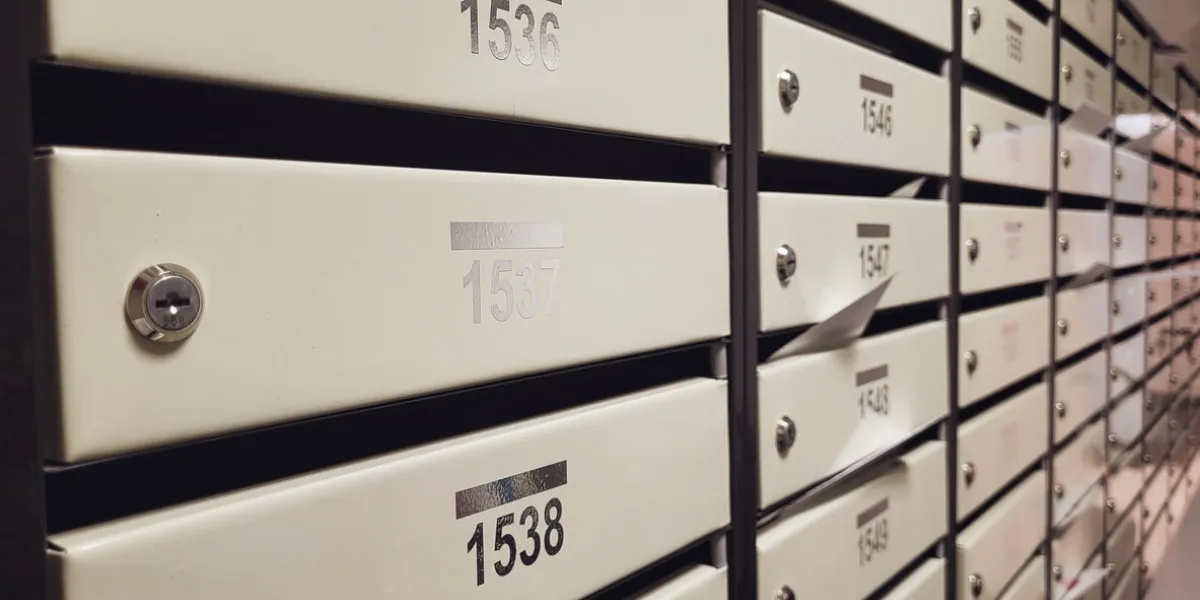 rows of mailboxes in the lobby of an apartment building, a lot of mailboxes with apartment numbers