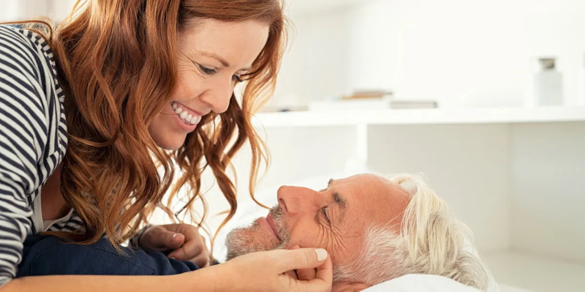 middle aged lovely woman lying on happy senior man and caresses him handsome old man and attractive woman enjoying spending time together while lying in bed mature smiling couple in love at home, copy space