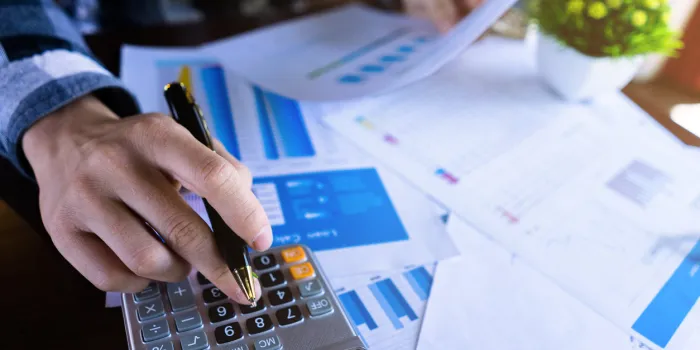 close up businessman using calculator and reading paper document about business data, accountancy document, graph profit company