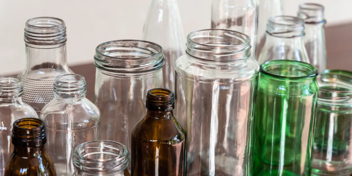 variety shape and color of empty glass container bottles, reuse waste things for ecology friendly concept, copy space