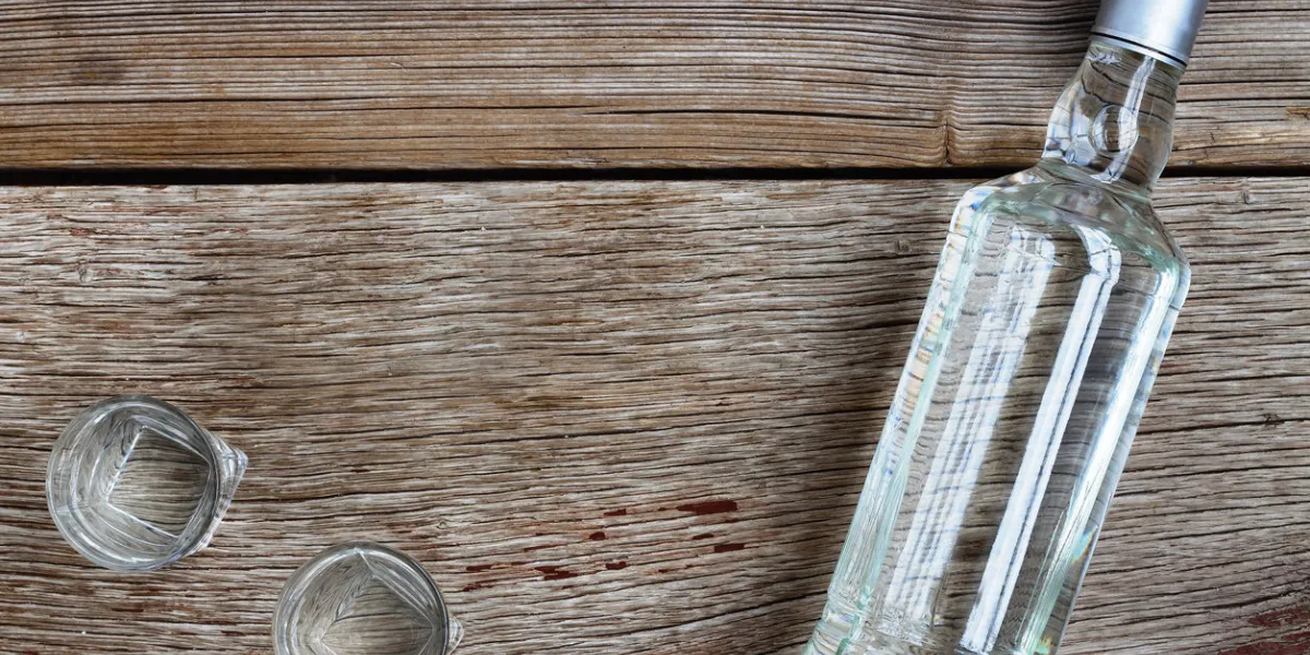 vodka luxury vodka bottle with shot glasses on the board on wooden background