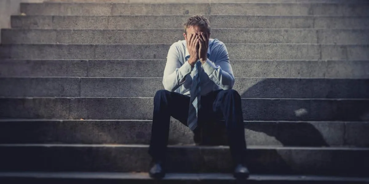 young business man crying abandoned lost in depression sitting on ground street concrete stairs suffering emotional pain, sadness, looking sick in grunge lighting
