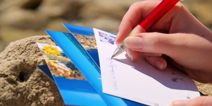 writing a picture postcard in holiday