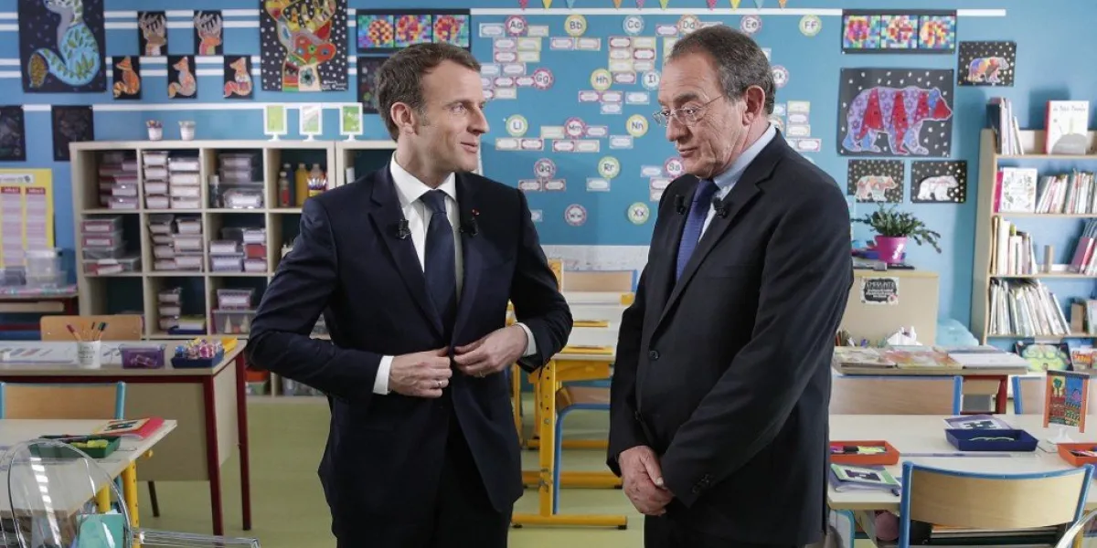 french president emmanuel macron (l) talks with french journalist jean-pierre pernaut (r) after being interviewed inside the classroom on french tv channel tf1 at the school in berd'huis, on april 12, 2018 (photo by yoan valat   pool   afp)
