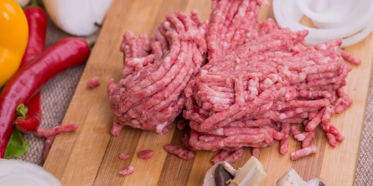 raw ground pork and fresh vegetables on the board