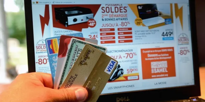 a person shows credit cards in front of a computer screen displaying electronics goods on sale on july 8, 2014 in lille afp photo   denis charlet (photo by denis charlet   afp)