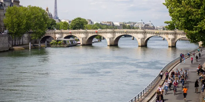 paris, france - may 11, 2017  a group of cyclists next to the river seine
