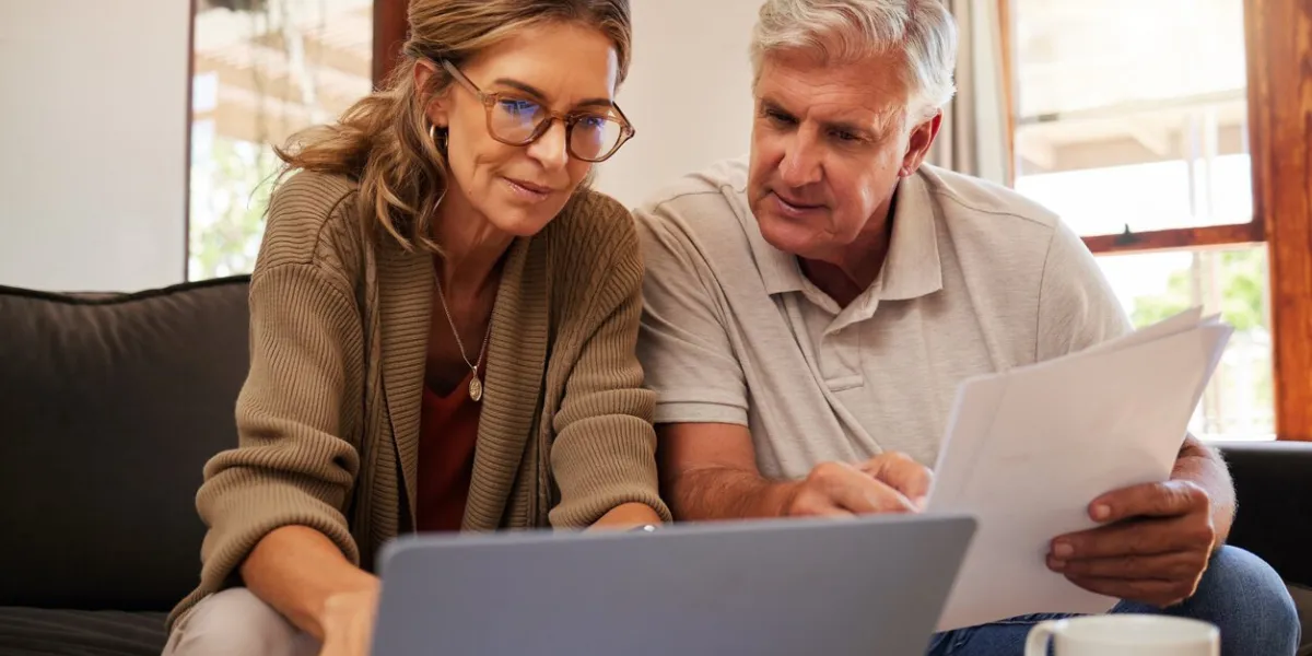 retirement couple budget, finance and investment planning, loan and paper bills with laptop technology in home mature people money, cash savings or legal insurance document report on online bank