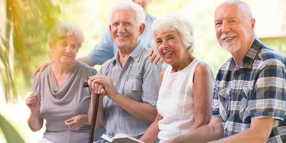 smiling elderly people spending time together at patio of nursing house
